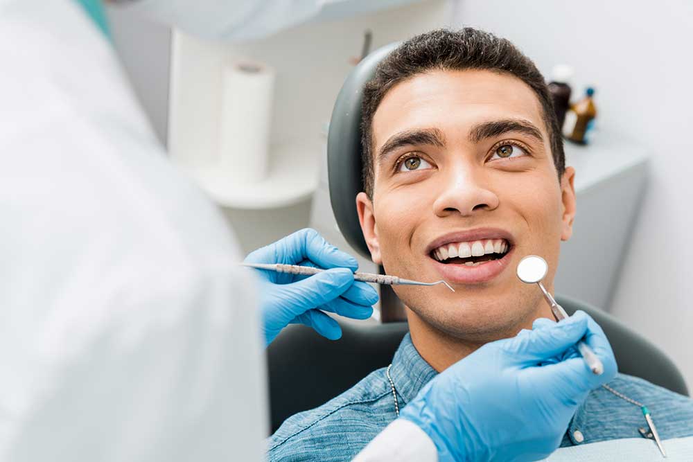 cheerful african american man with during examination in dental clinic